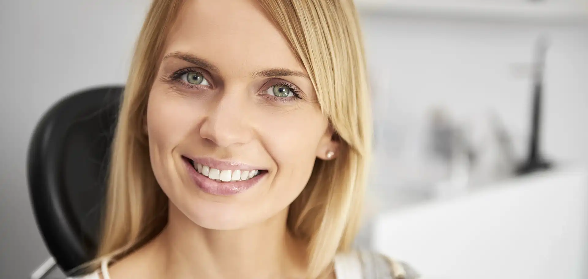 Uśmiechnięta kobieta o blond włosach w klinice SmileClinic