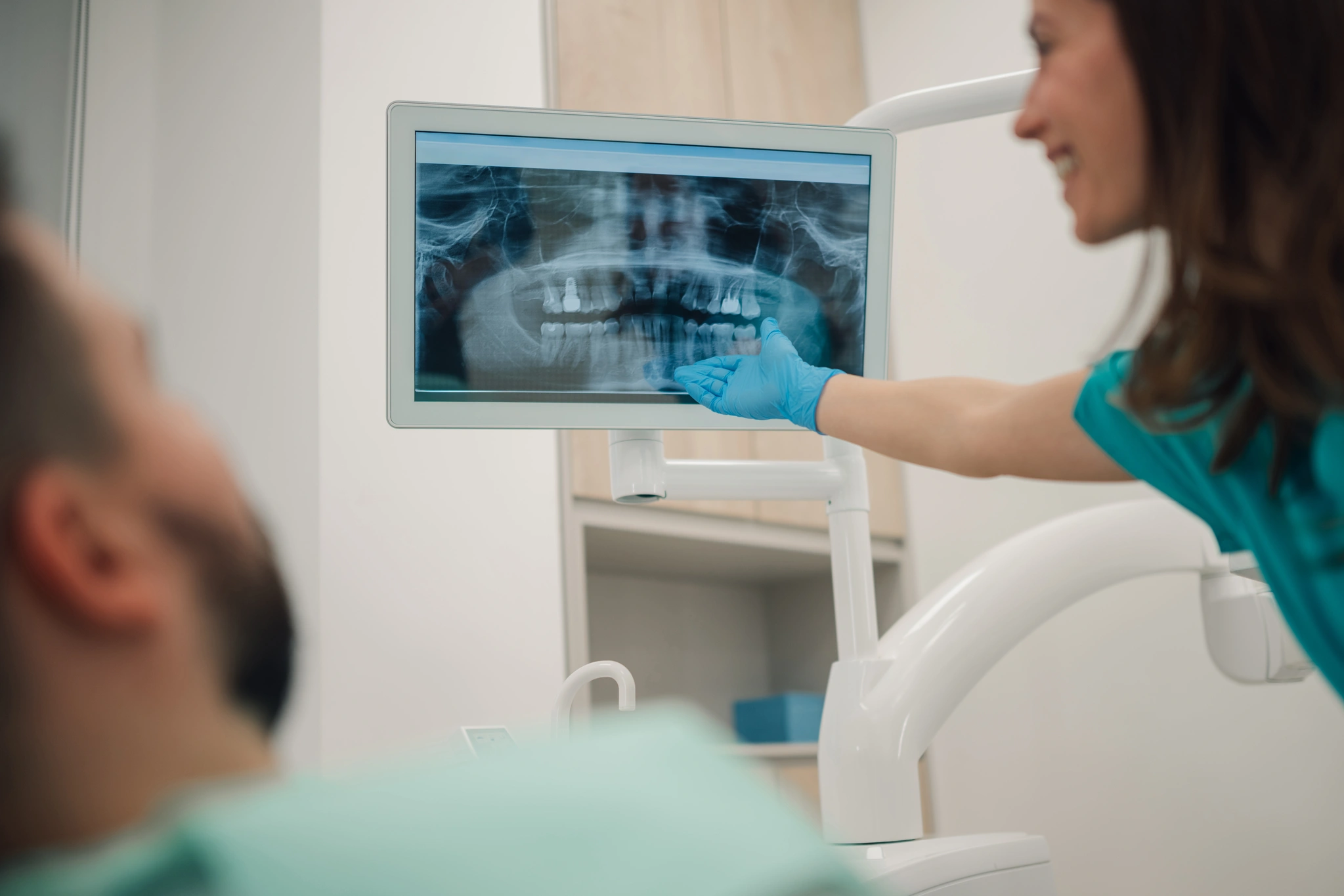 Dentystka omawiająca zdjęcie RTG z pacjentem przed zabiegiem implantologicznym